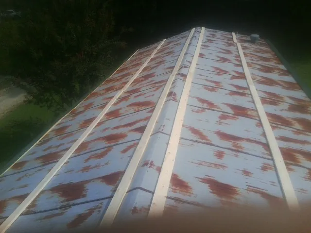 Rusted metal roof panels with new wood purlins before replacement — Storm Damage Roof Repair in Monclova by Roofing Brothers