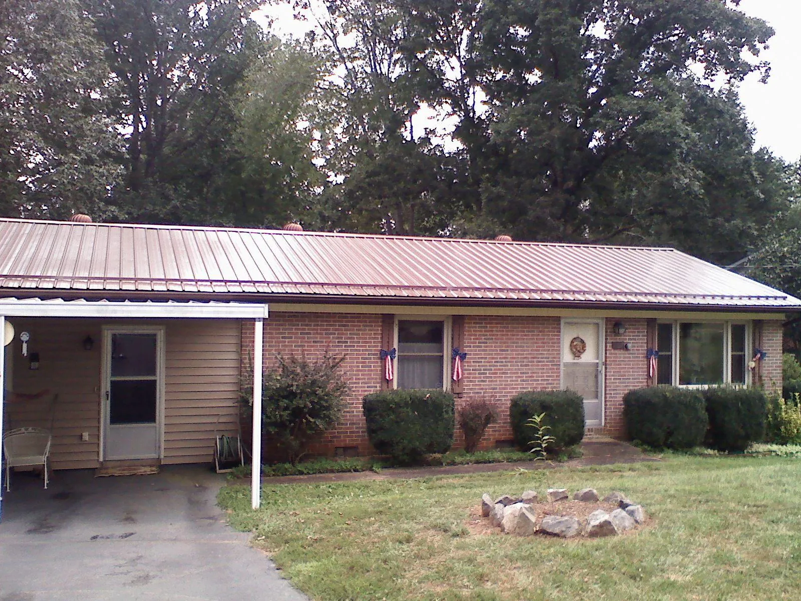 Bronze metal roof and carport on a brick ranch home — Roof Repair work by our crew in Monclova